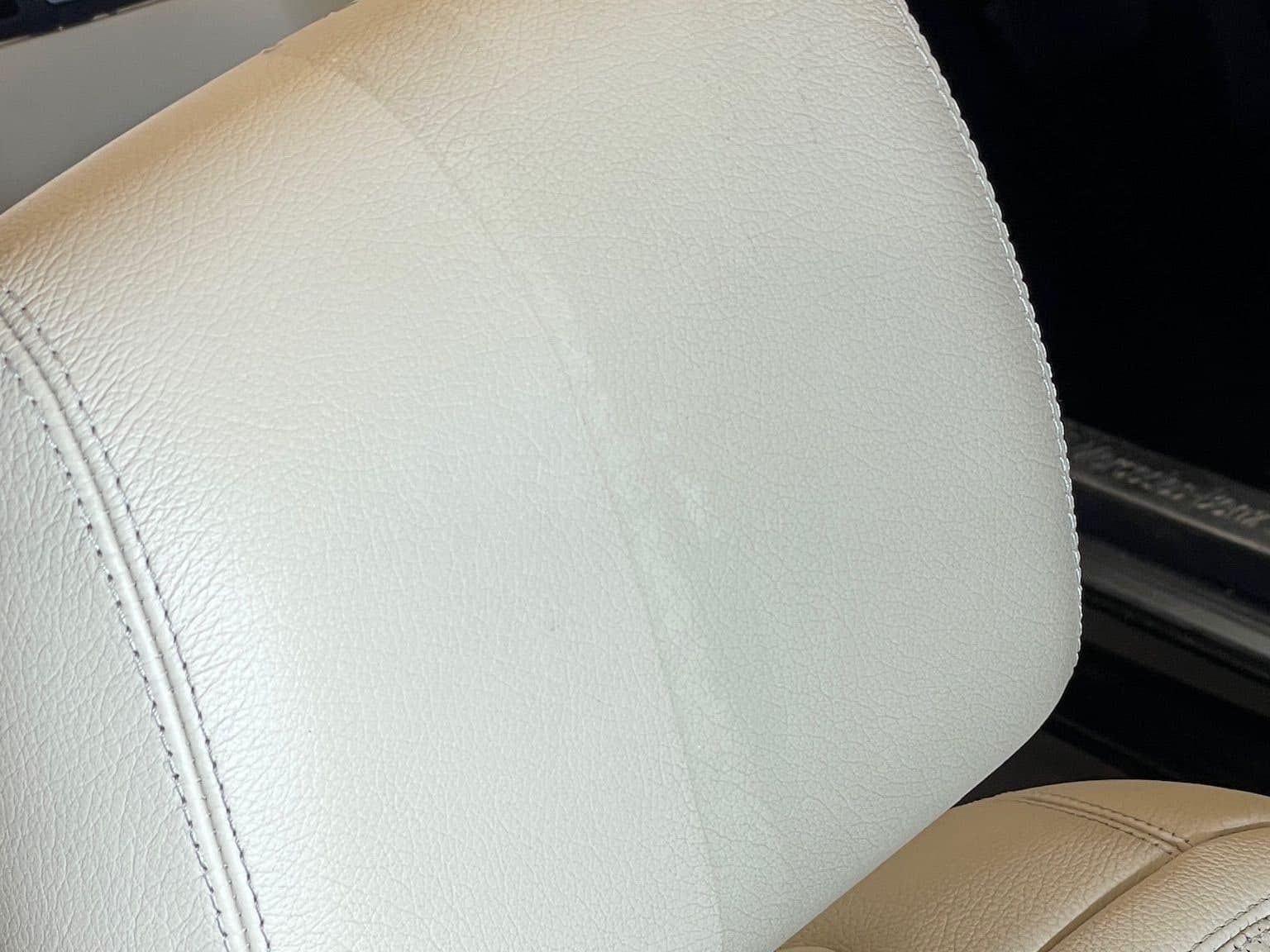 Nakkestøtte i lyst skinn i en Mercedes S-klasse, halvveis renset — den rensede halvdelen er tydelig lysere